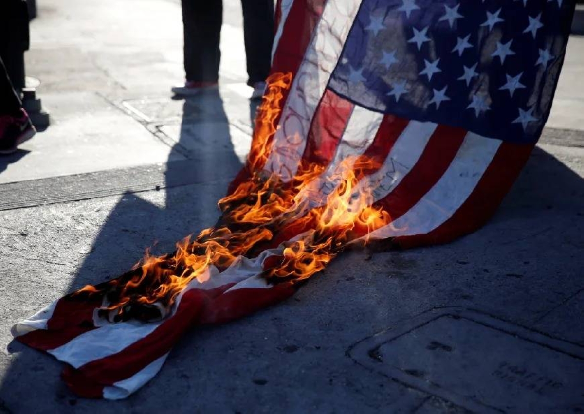 أمريكي يحرق العلم بعد قرار ترمب بمنع تدنيسه